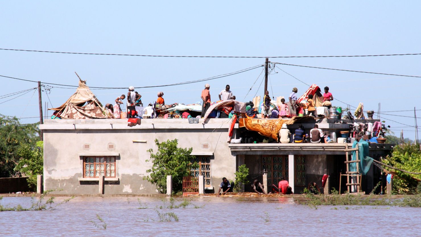 Residents flee to the roof of a house in Mozambique on Friday to escape the floods.