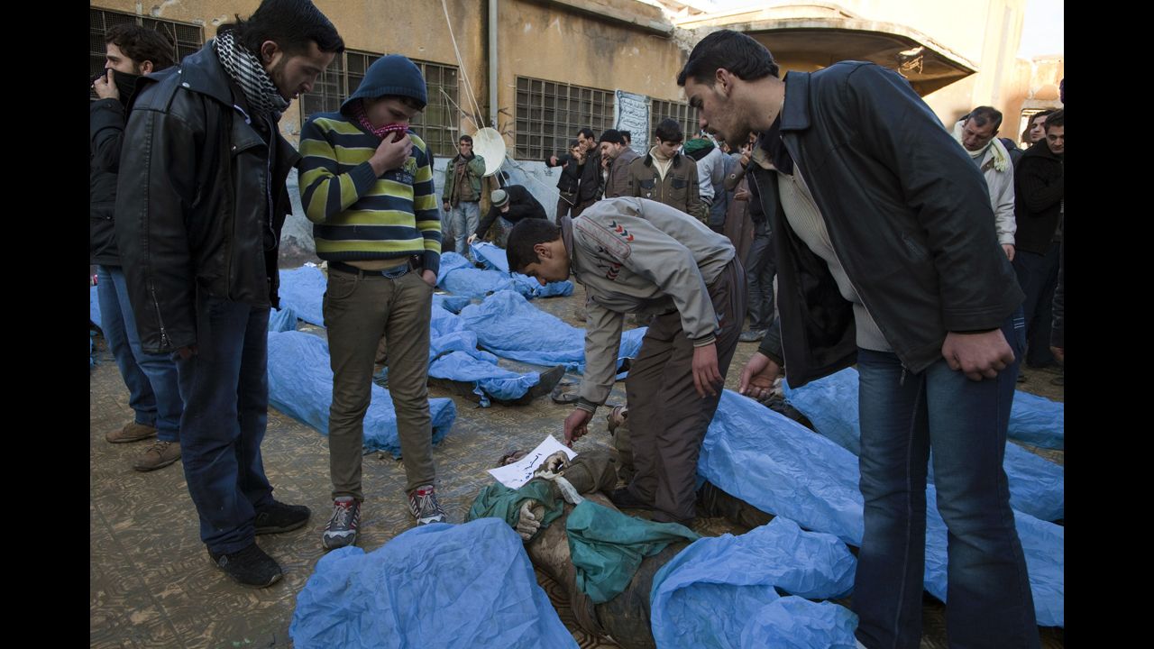 Men look for their relatives amongst the blue bags.