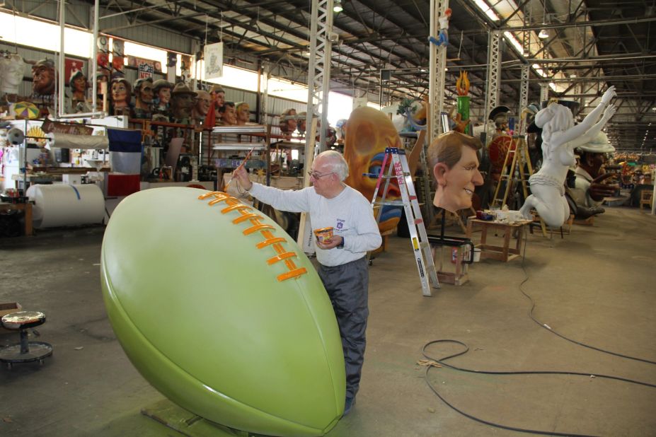 Workers at Mardi Gras World put the finishing touches on football-themed floats.
