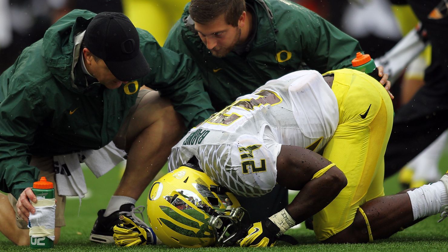 Trainers attend to a University of Oregon player hurt in a football game in Corvallis, Oregon, on November 24, 2012.