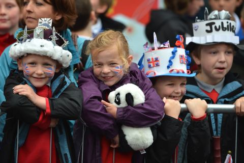 Children wearing homemade paper crowns look on  as Queen Elizabeth II and Prince Philip, Duke of Edinburgh, visit Macartin's Cathedral for Jubilee celebrations in Enniskillen, Northern Ireland. 