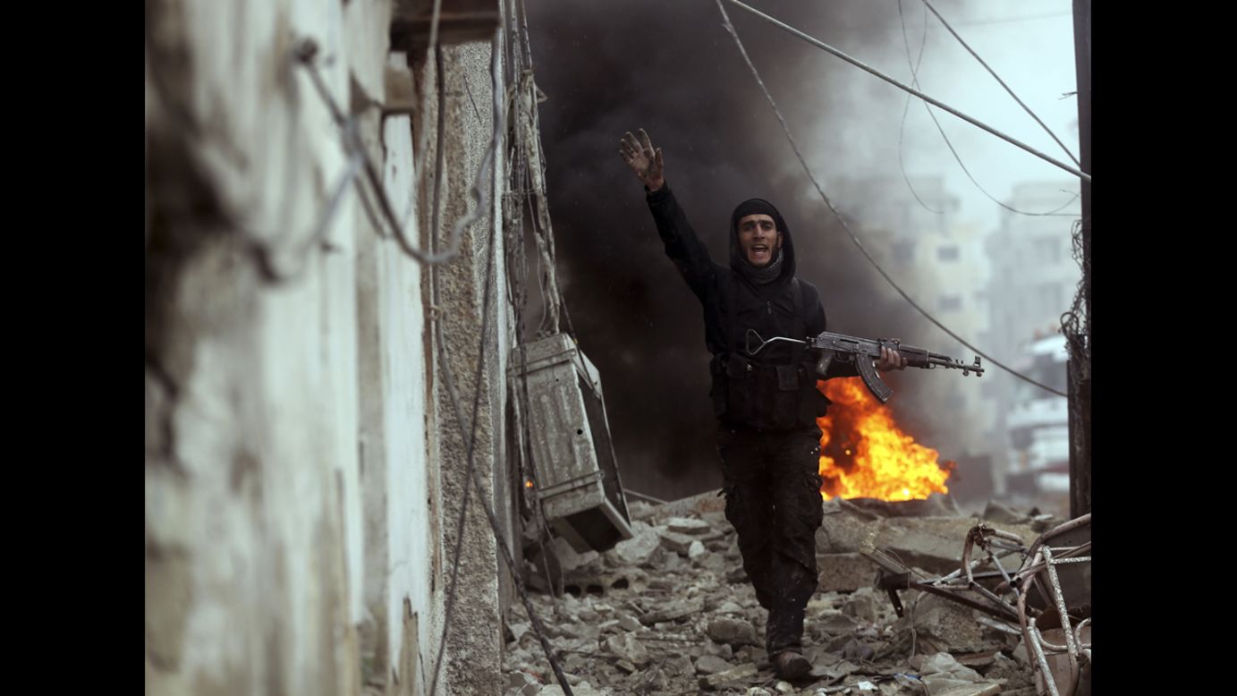 Photographer Goran Tomasevic, <a href="http://blogs.reuters.com/photographers-blog/2013/01/30/deadly-sniper-shot-through-the-lens/" target="_blank" target="_blank">embedded with the Free Syrian Army</a>, captured an intense firefight and the death of a rebel fighter in Damascus on Wednesday, January 30. Here, a Free Syrian Army fighter gestures in front of a burning barricade during heavy fighting in the Ain Tarma neighborhood of Damascus.