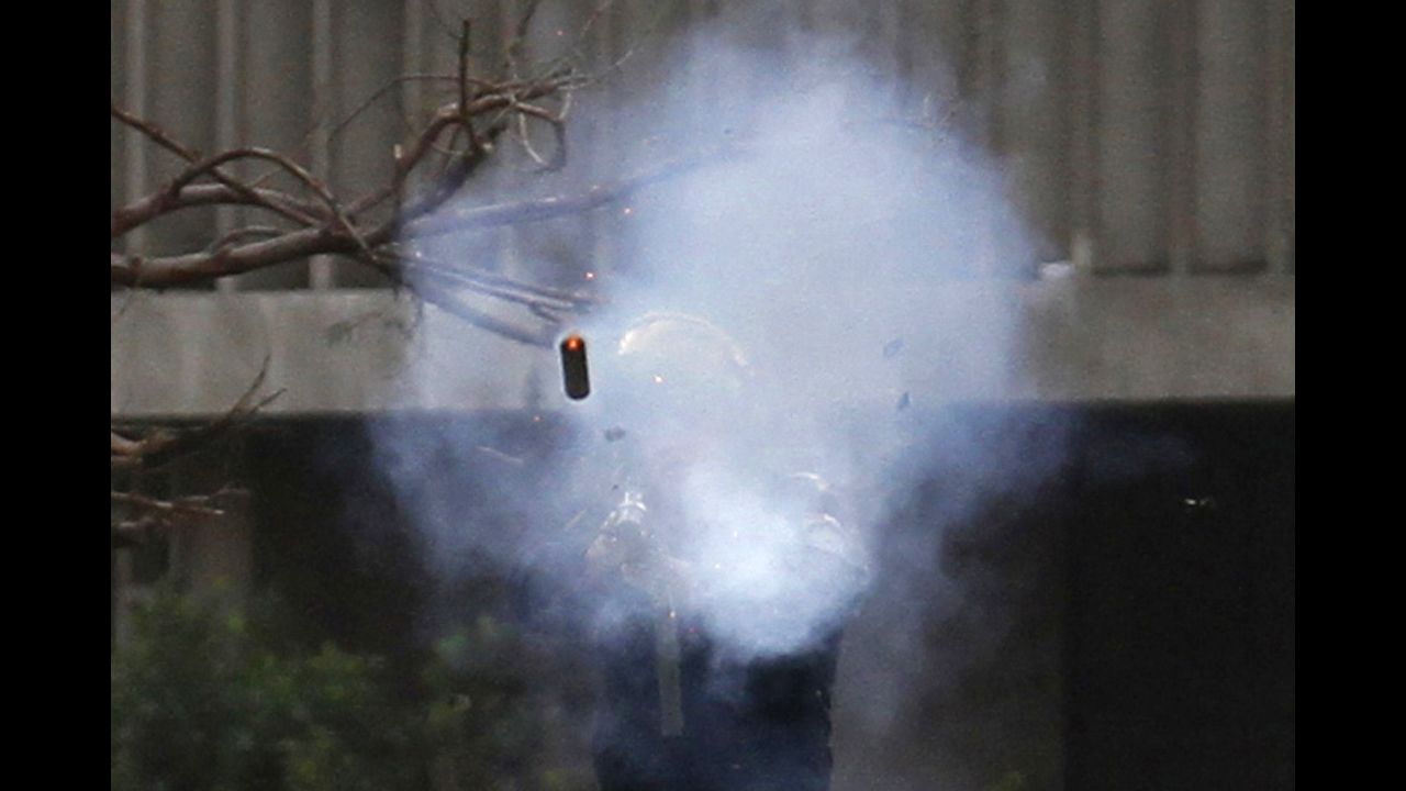 A police officer fires a tear gas canister during clashes with protesters near Tahrir Square on January 30.