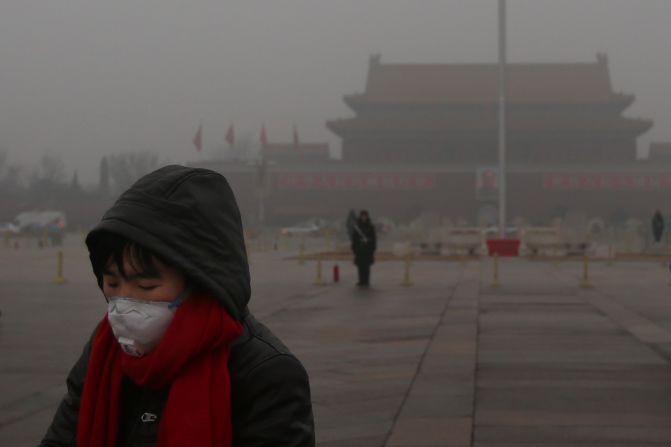 Un turista con careta puesta pasea por la plaza de Tiananmen durante una contaminación severa el 31 de enero de 2013, en Beijing,