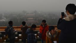 Japanese tourists take photos from the historic Jingshan Park as smog continues to shroud Beijing on January 31, 2013.  Doctors in Beijing said on January 31 that hospital admissions for respiratory complaints rose in recent days during the latest bout of air pollution to cover northern China.          AFP PHOTO/Mark RALSTON        (Photo credit should read MARK RALSTON/AFP/Getty Images)