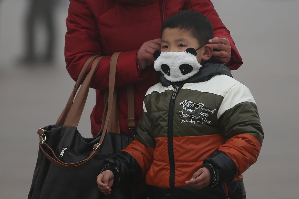 A small child wears a panda mask at Tiananmen Square.