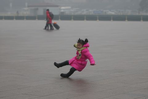 A child slips on frozen pavement in Tiananmen Square.