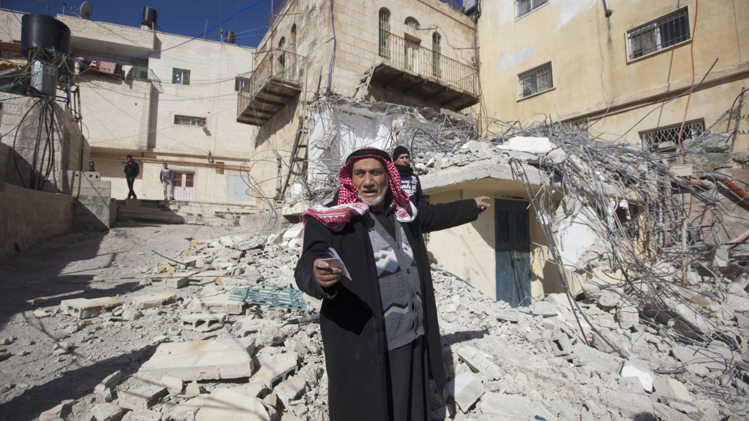 A Palestinian man points toward a home demolished by Israeli bulldozers in Arab East Jerusalem on January 15.