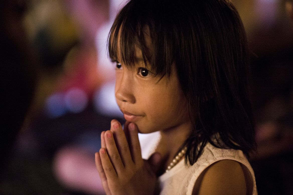 A Cambodian girl prays for the late former King Norodom Sihanouk in front of the Royal Palace on Thursday.