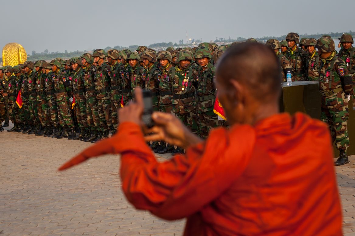 A monk takes photographs of the military as they rehearse for the funeral of former King Norodom Sihanouk outside the Royal Palace on Thursday.