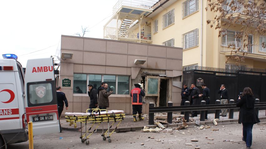 People stand outside the entrance of the U.S. Embassy in Ankara, Turkey on February 1 after a blast killed two security guards and wounded several other people.