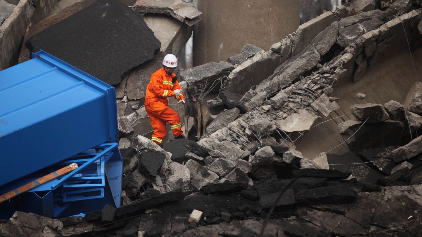 A rescuer looks for survivors at the scene near the city of Sanmenxia, Henan province, on February 1, 2013.