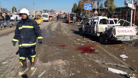 An Iraqi firefighter walks past the scene of a car bombing followed by an assault on a police headquarters, which killed at least 20 people in the disputed northern city of Kirkuk, Iraq, on Sunday, February 3.