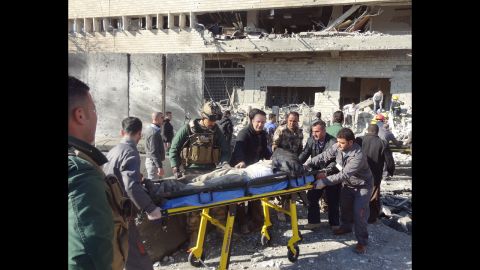 Iraqi rescuers wheel a stretcher from the scene.