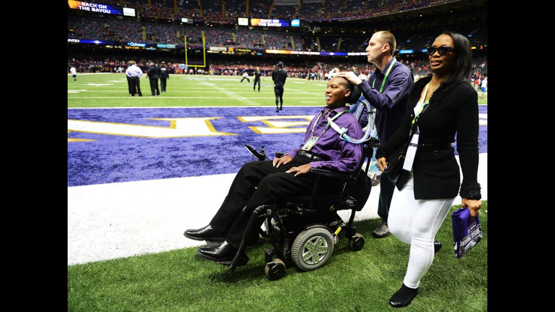 O.J. Brigance, left, senior player development adviser for the Baltimore Ravens, makes his way across the field with his wife, Chanda, prior to the start of Super Bowl XLVII. Brigance, a former Ravens player, was diagnosed with Lou Gehrig's disease in 2007.