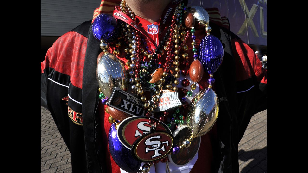 A 49ers fan is weighed down with team paraphernalia poses outside the Superdome before the start of the game.