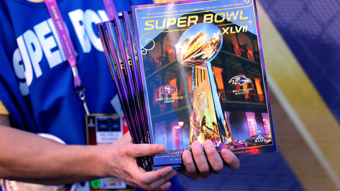 Super Bowl programs are sold outside the stadium as fans stream into the Superdome.