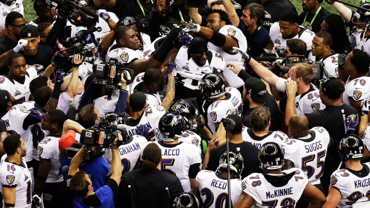 Baltimore Ravens players gather around team leader Ray Lewis as he leads them in a rally on the field just before the start of the game.