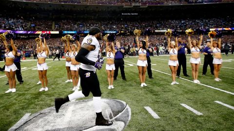 Veteran Baltimore Ravens linebacker Ray Lewis runs onto the field as cheerleaders and fans cheer.