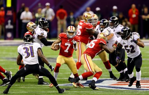 Quarterback Colin Kaepernick of the 49ers runs with the ball in front of Ravens safety Bernard Pollard, No. 31.