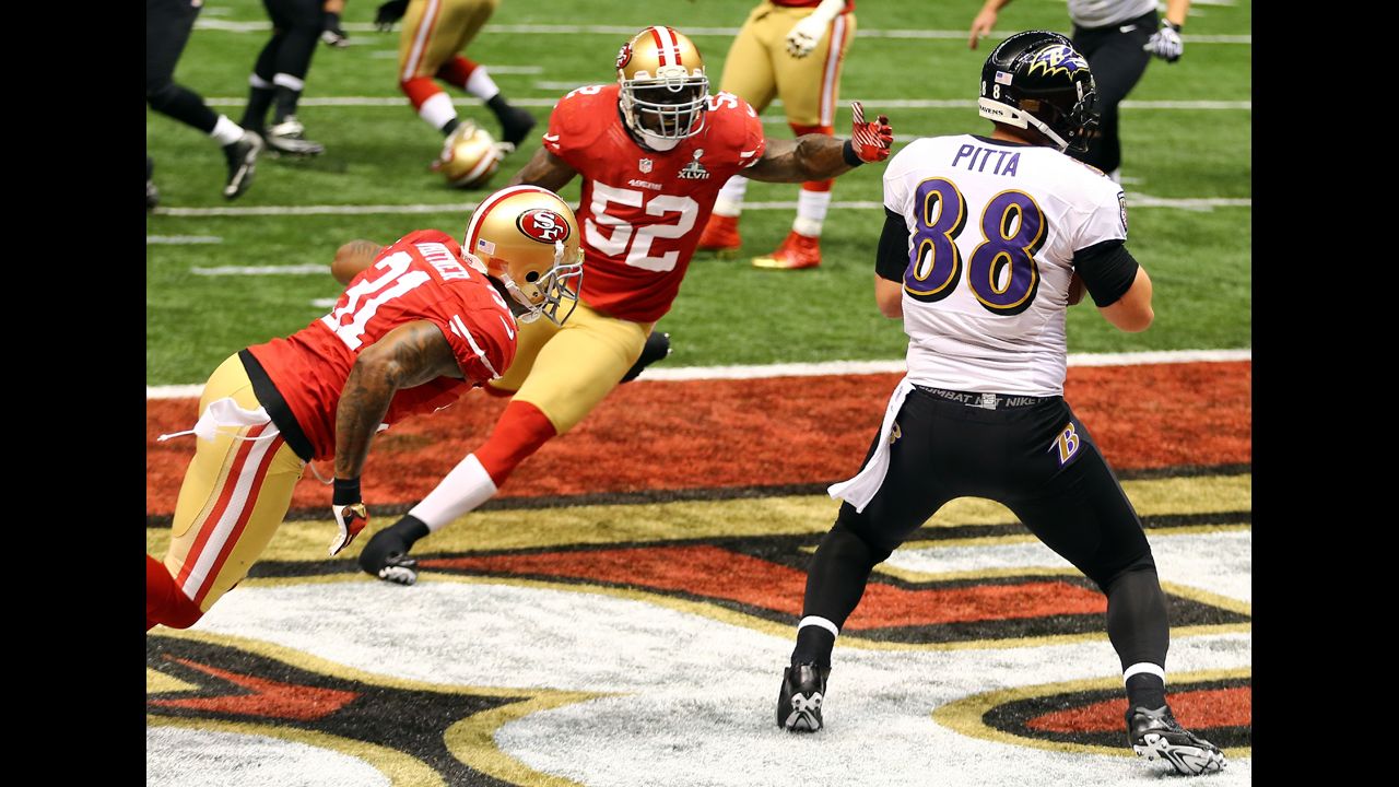Dennis Pitta of the Baltimore Ravens catches a touchdown pass in front of  Donte Whitner, left, and Patrick Willis of the San Francisco 49ers.
