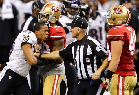 Baltimore Ravens cornerback Cary Williams reacts angrily after a play as head linesman Steve Stelljes and 49ers fullback Bruce Miller attempt to hold him back.