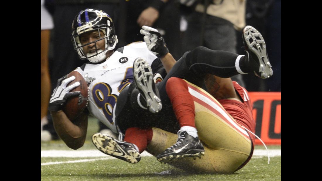 Ed Dickson of the Baltimore Ravens is brought down by Donte Whitner of the San Francisco 49ers.