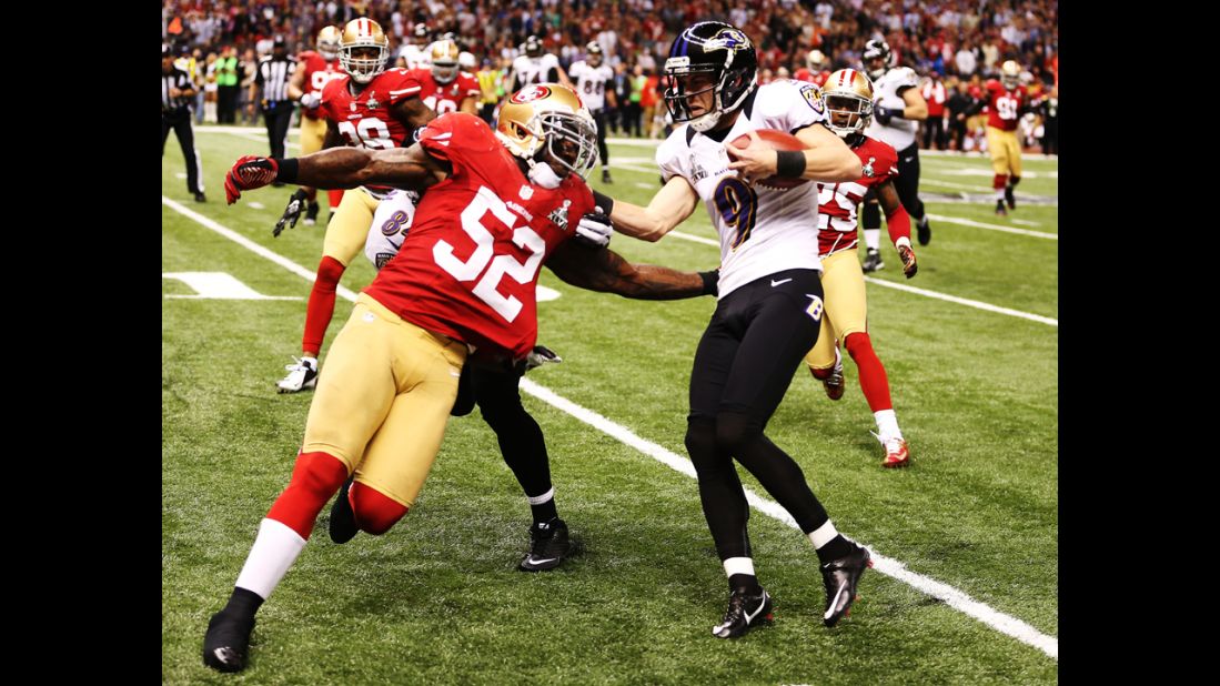 Kicker Justin Tucker of the Baltimore Ravens is stopped short of a first down on a fake field goal attempt in the second quarter. Patrick Willis is the tackler.