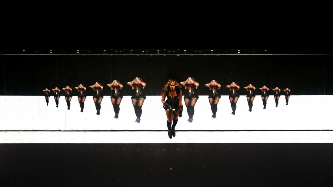 Beyonce dances in front of a screen on stage.