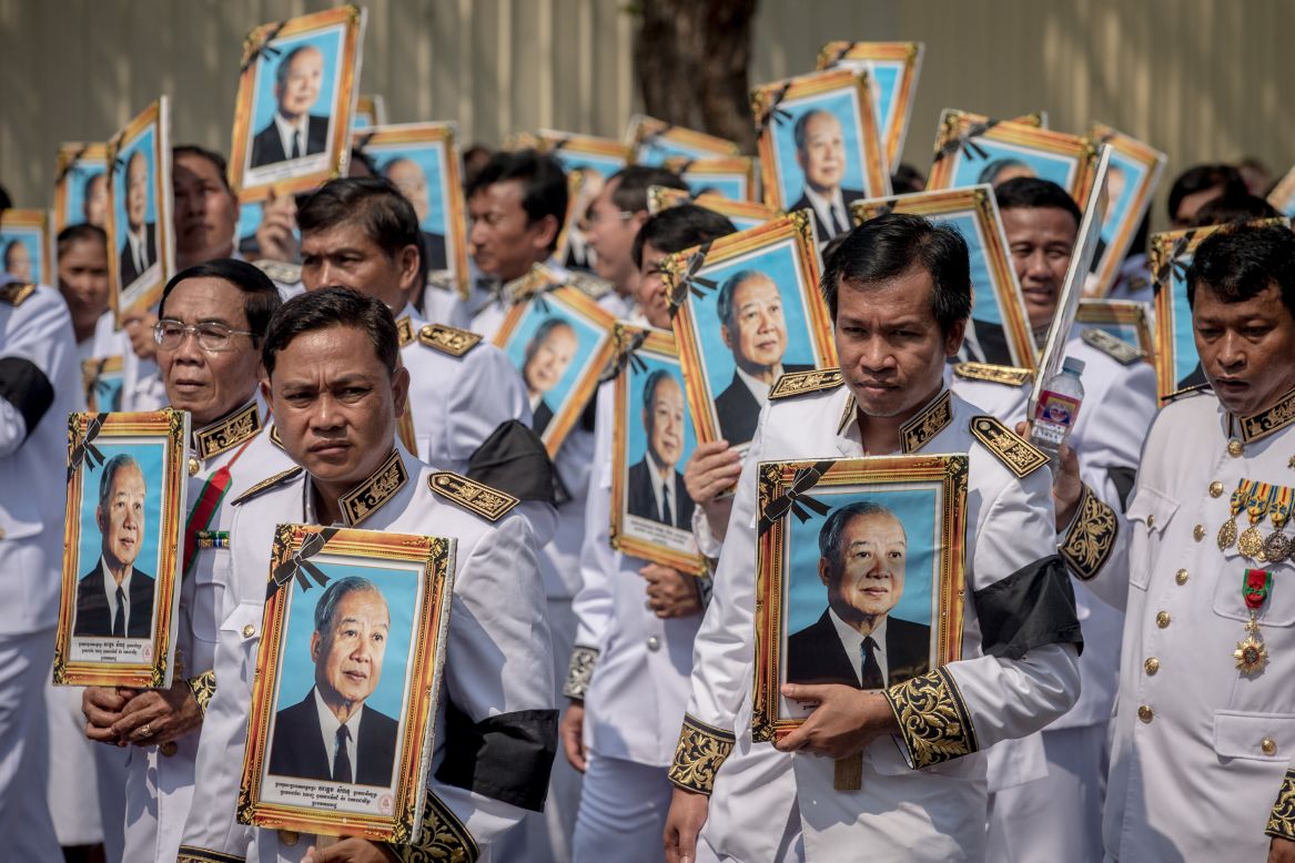 Mourners carry portraits of former King Norodom Sihanouk during the funeral procession on Friday in Phnom Penh.