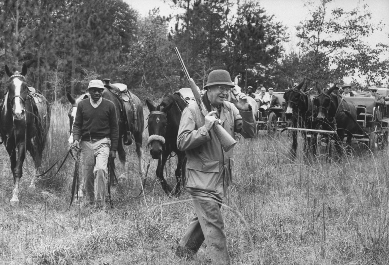 Dwight D. Eisenhower totes a gun on a quail hunting trip at the plantation of his first secretary of the Treasury, George Humphrey, in Georgia in January 1961.  