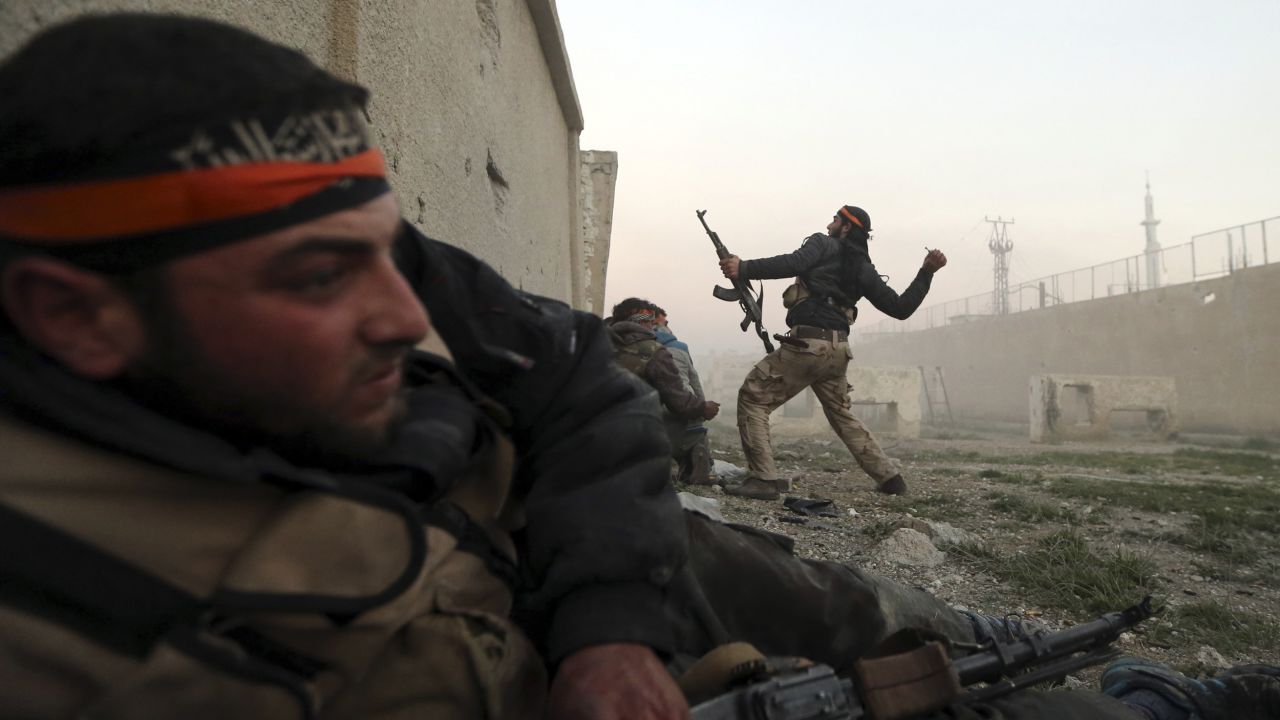 A rebel fighter throws a hand grenade inside a Syrian Army base in Damascus on February 3.