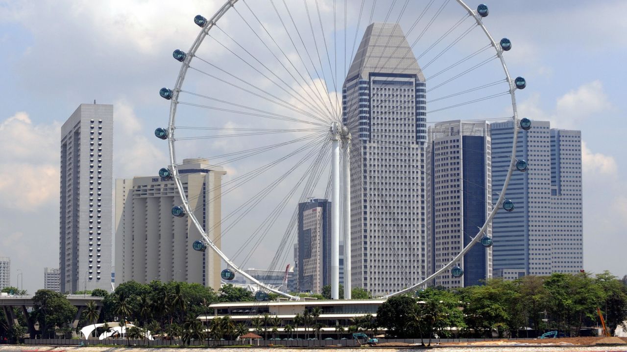In this picture taken on April 15, 2008, the 165 meter high Singapore flyer stands against a panorama of highrise buildings in Singapore. Officials in Singapore have changed the direction of the world's biggest observation wheel because feng shui masters said it was taking good fortune away from the city, a report said August 9. 2008. The Singapore Flyer, which opened earlier this year, had originally revolved so that it rose to face the business district and went down overlooking the sea, the Strait Times newspaper said. AFP PHOTO/ROSLAN RAHMAN (Photo credit should read ROSLAN RAHMAN/AFP/Getty Images) 
