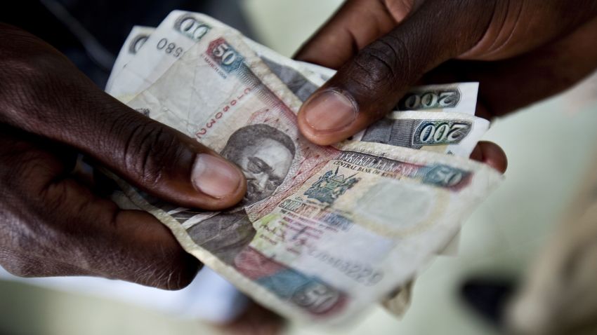 Men exchange Kenyan Schillings, the currency of Kenya, in Nairobi, Kenya, on Thursday, Feb. 25, 2010. Kenya National Bureau of Statistics said it will postpone publishing February's inflation data by at least a day or two to prepare for the release of a revised consumer price index basket. Photographer: Trevor Snapp/Bloomberg via Getty Images