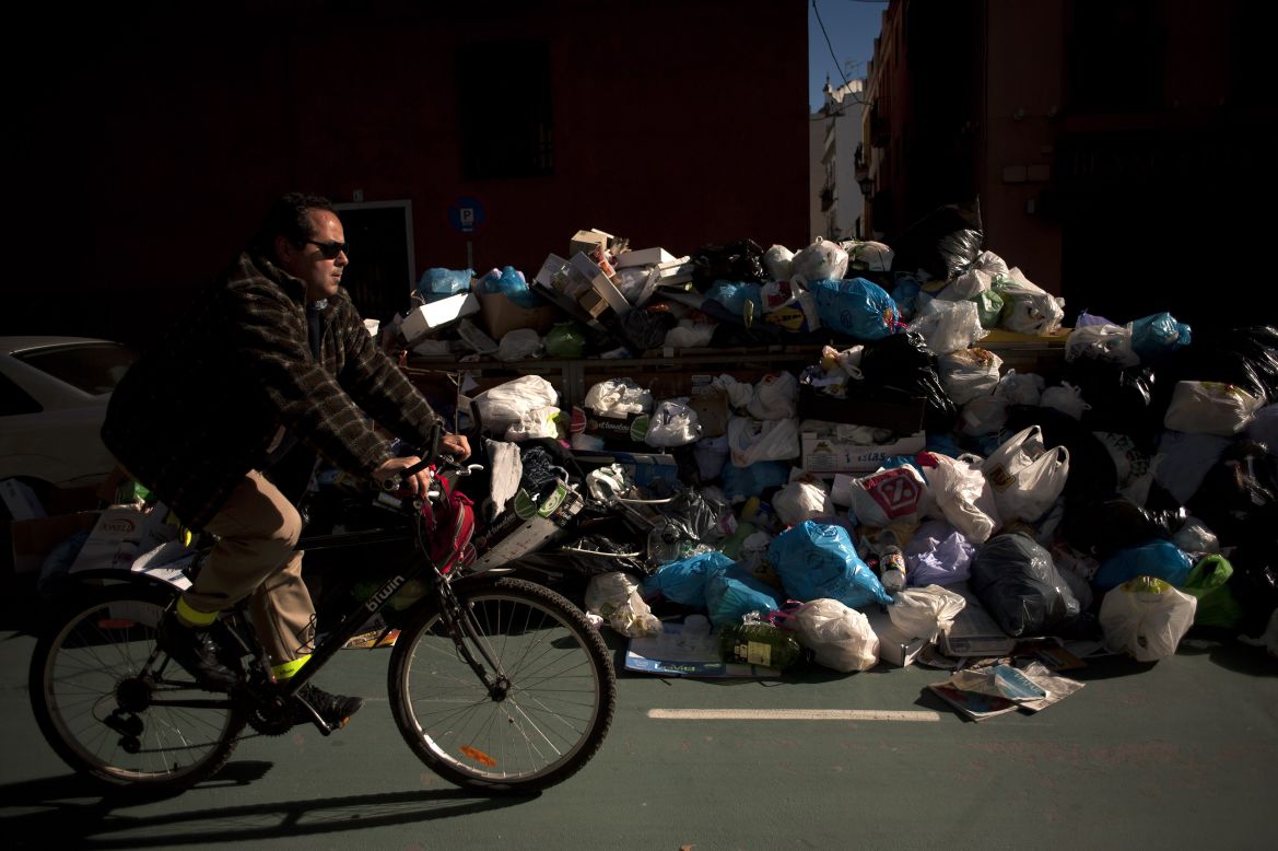 A man rides past uncollected rubbish in Seville on February 4. 