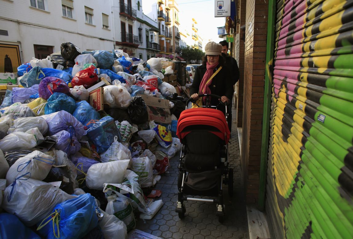 A woman pushes her baby through the trash-choked streets on February 5.