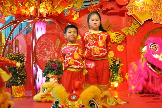 A standard lion head weighs about five pounds, or 2.2 kilograms. A more traditional head is about twice that weight.<br /><br />These young and proud performers, Keong Ka Ching (left) and Chiu Po Ying, ages five and nine respectively, are only old enough to play the "baby lion."