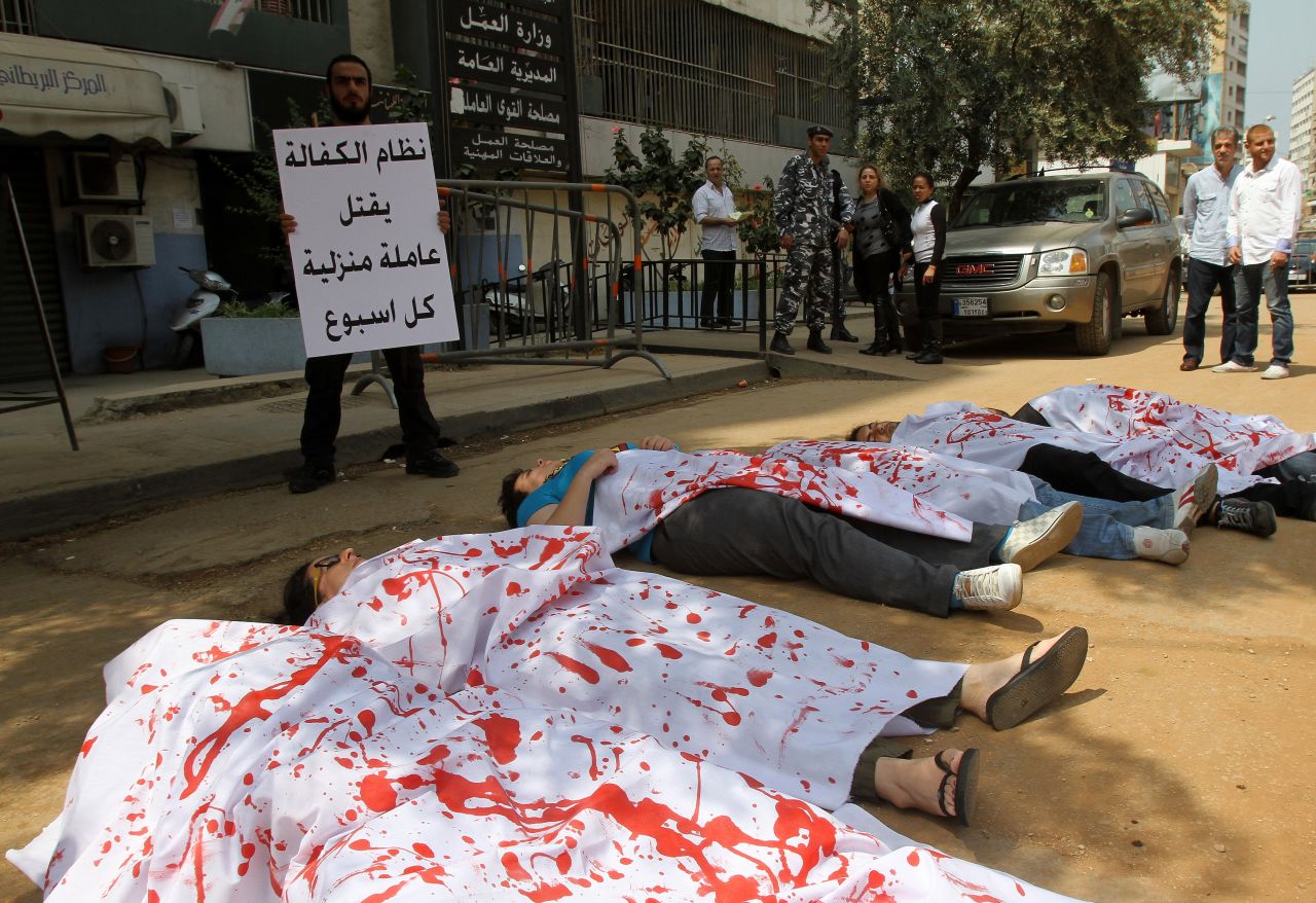 Activists participating in a flash mob don bloodied sheets as they lie in the streets outside the Ministry of Labour in Beirut to protest over violence against migrant workers. The action was held in April 2012, the month after a 33-year-old Ethiopian maid killed herself shortly after being filmed being beaten in public by a Lebanese man.