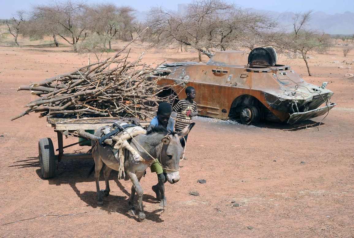 A child leads a donkey cart past a destroyed Malian army armored vehicle near Douentza, Mali, on February 5.  