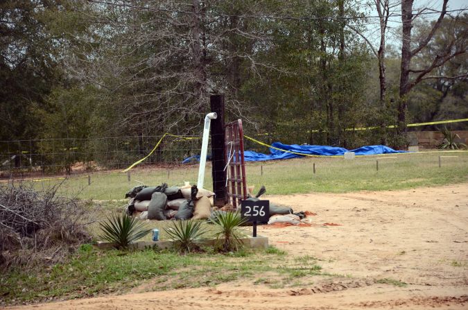A white PVC pipe used by FBI agents and Dale County, Alabama, negotiators to communicate with Dykes protrudes out of the ground on Monday, February 4. For almost a week, Dykes held a 5-year-old boy hostage in a bunker after taking the boy from his school bus and killing its driver.