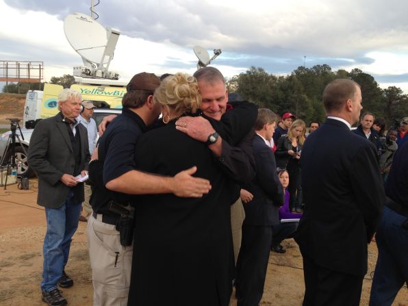 Dale County Schools Superintendent Donny Bynum hugs Dale County Sheriff Wally Olson and an unidentified woman after the standoff.