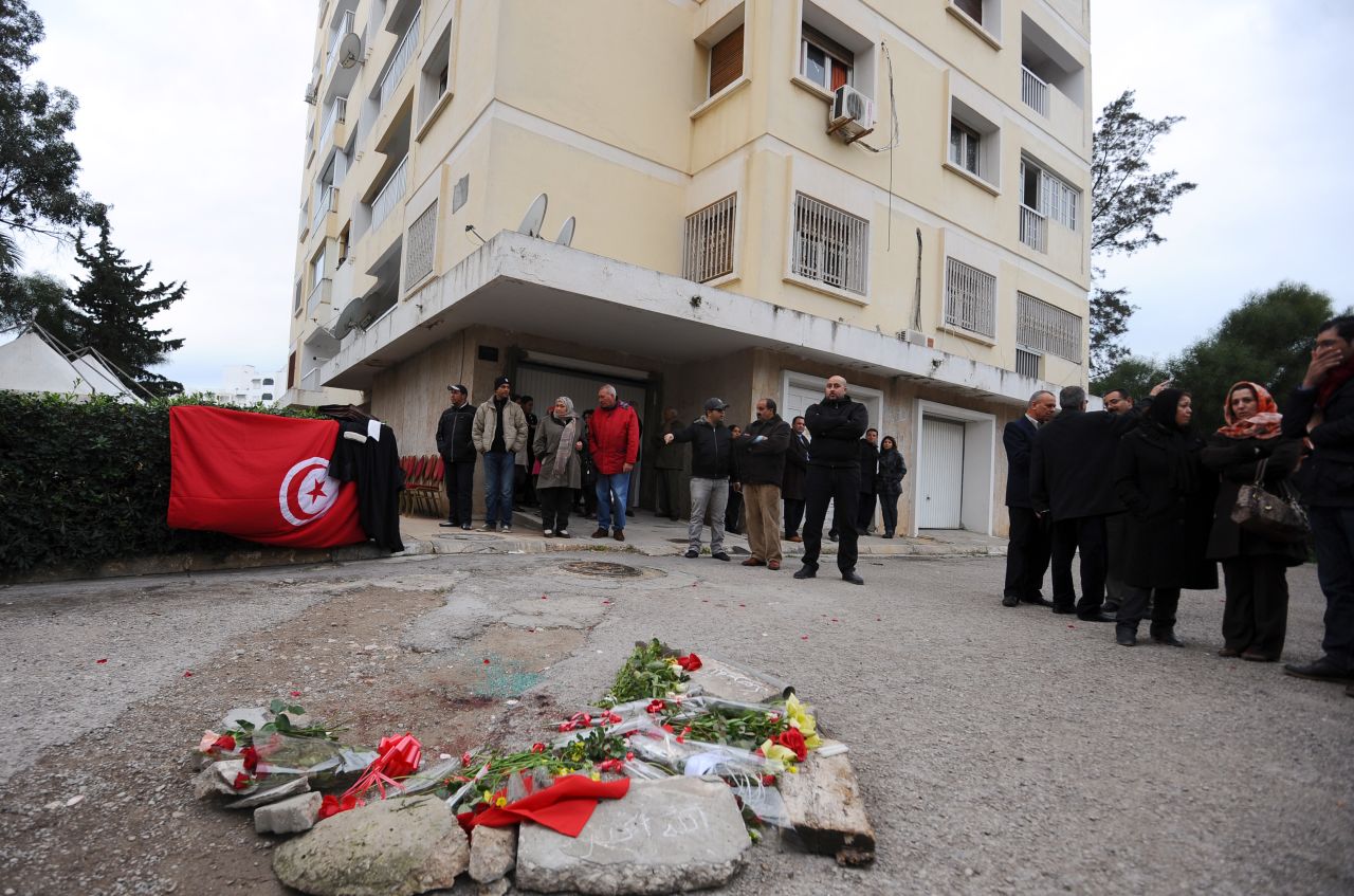 A national flag and flowers are displayed in front of the home of Tunisian opposition leader.