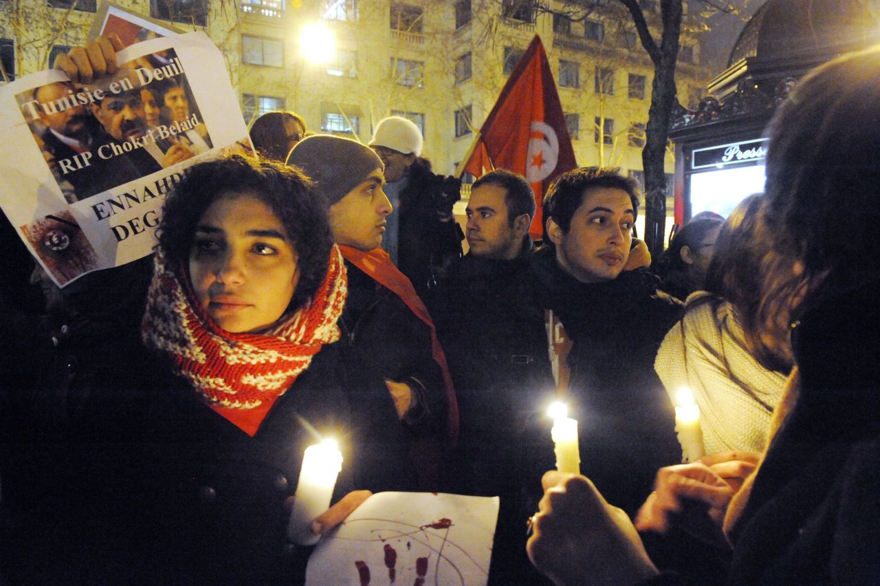 A protester holds a poster reading 'Tunisia in mourning, RIP Chokri Belaid, Ennahdha get out,' on February 6, 2013 in Paris.