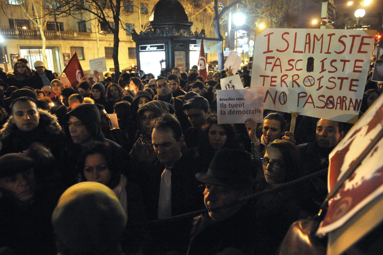 A protester holds a placard reading: 'Wake up, they're killing Democracy' during a demonstration in Paris.