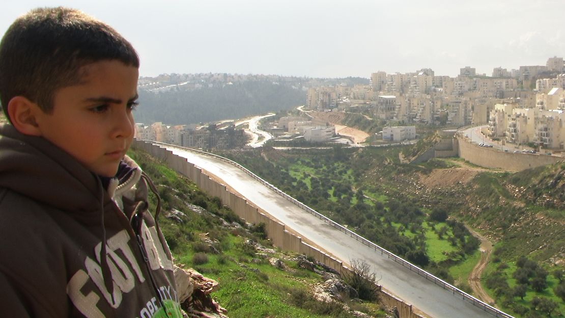 Emad's son Gibreel looks over at the Israeli settlements