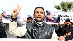  Tunisian protester flashes the sign of the victory holding a banner during a demonstration against the assassination of vocal government critic Chokri Belaid (featured on the banner) on February 7, 2013 in Siliana northwest of Tunis. 