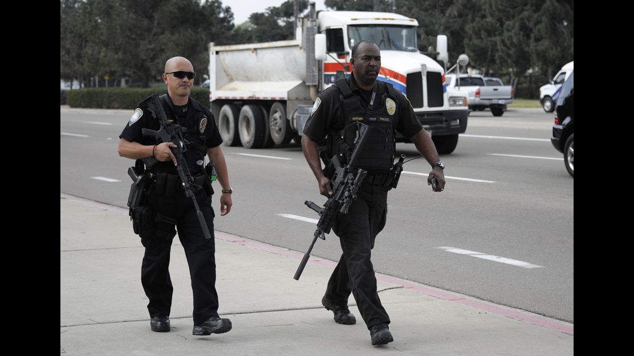 San Diego Harbor Police officers near Naval Base Point Loma armed with high-powered firearms walk along a street on February 7 in San Diego.