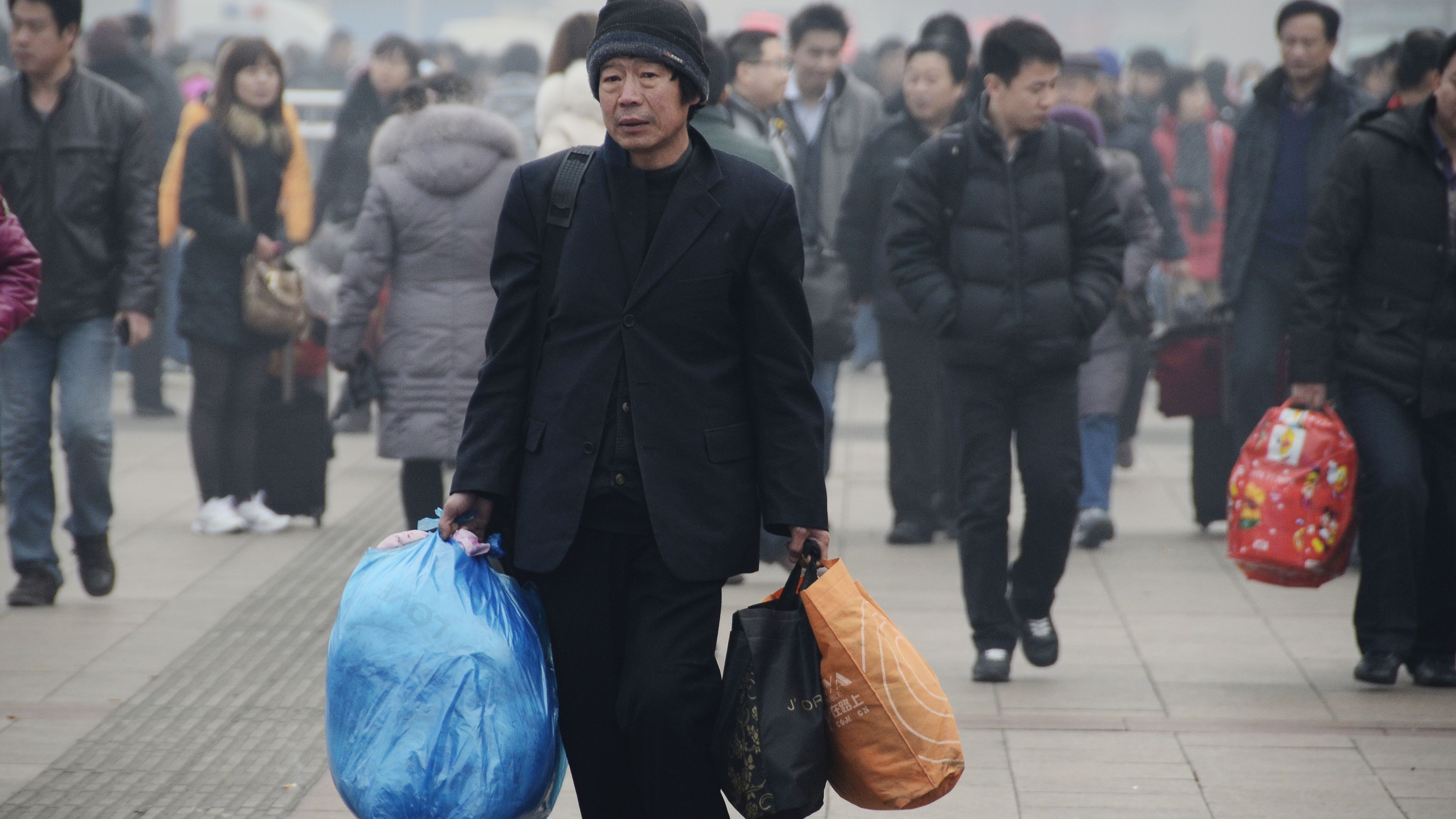A man prepares to take the train at the entrance of Beijing Railway Station on January 28. 