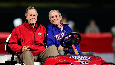 President George H.W. Bush, left, and his son President George W. Bush appear at a World Series game in October 2010.