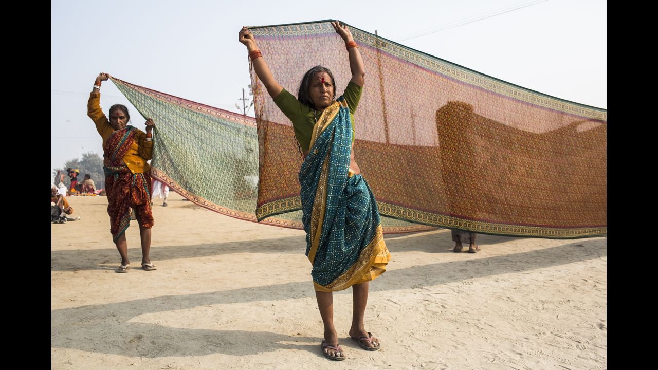 A Hindu devotee holds out a saree to dry after having bathed on the banks of the Ganges river on January 13.